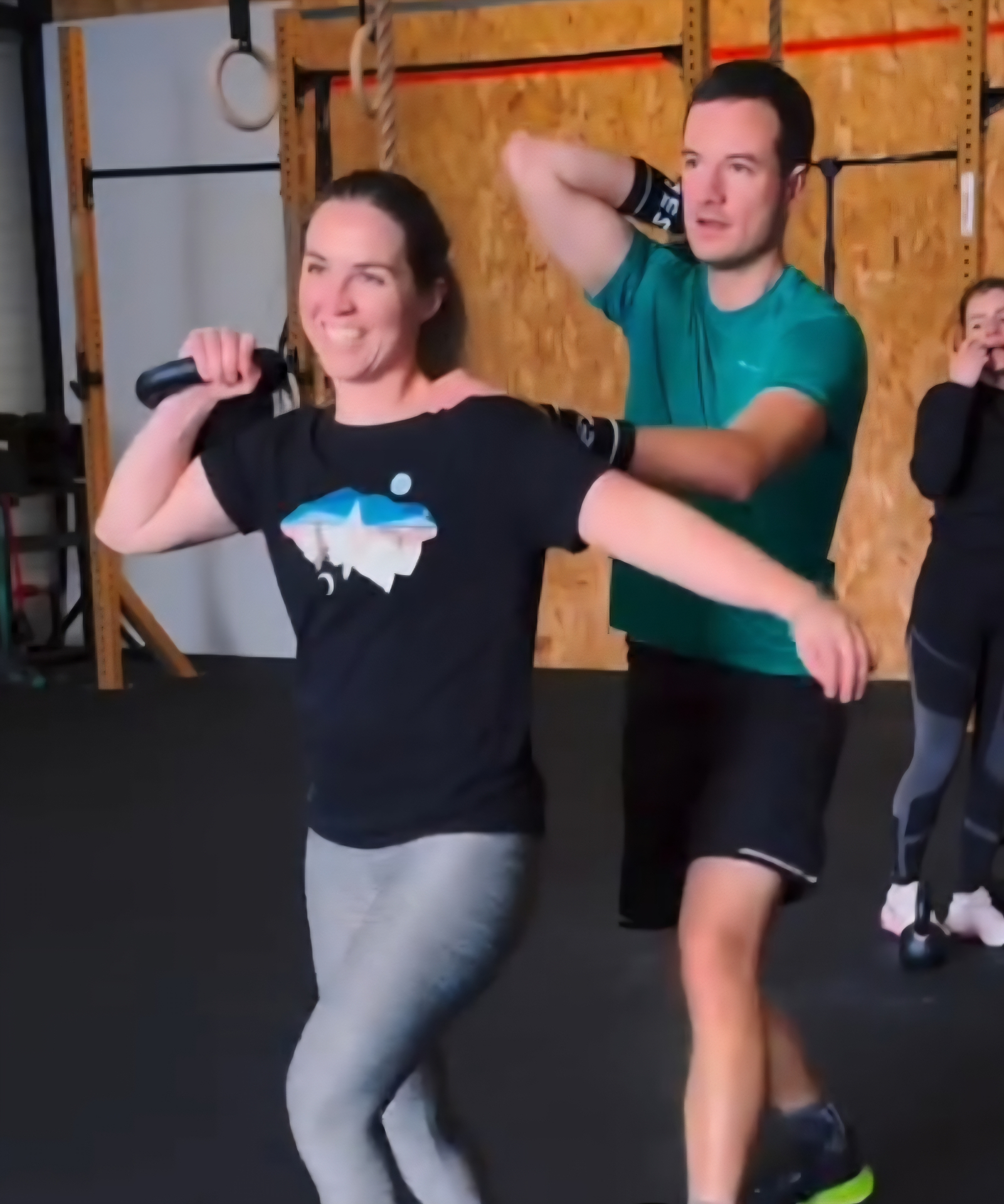 Adhérents CrossFit Chistera en plein cours collectif kettlebell — ambiance bienveillante, sourires, coach en arrière-plan, box familiale dans l'Est lyonnais